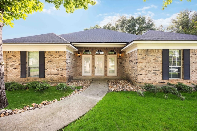 24526 Haigshire Dr, Tomball, TX 77375 - ranch-style home featuring a shingled roof, brick siding, a front lawn, and a porch
