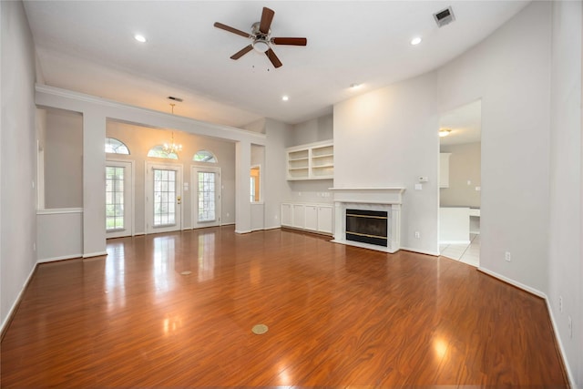 24526 Haigshire Dr, Tomball, TX 77375 - unfurnished living room featuring wood finished floors, a ceiling fan, a fireplace, a chandelier, and recessed lighting