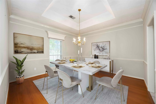 24526 Haigshire Dr, Tomball, TX 77375 - dining area with a chandelier, wood finished floors, a tray ceiling, and ornamental molding