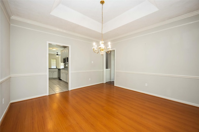 24526 Haigshire Dr, Tomball, TX 77375 - empty room featuring a chandelier, wood finished floors, crown molding, and a tray ceiling