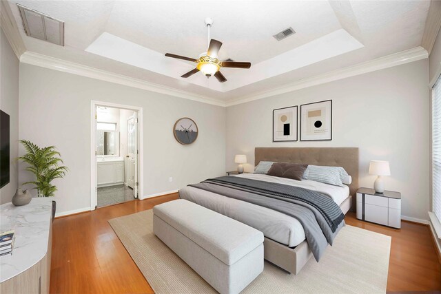24526 Haigshire Dr, Tomball, TX 77375 - bedroom with a raised ceiling, light wood finished floors, ornamental molding, ceiling fan, and ensuite bathroom
