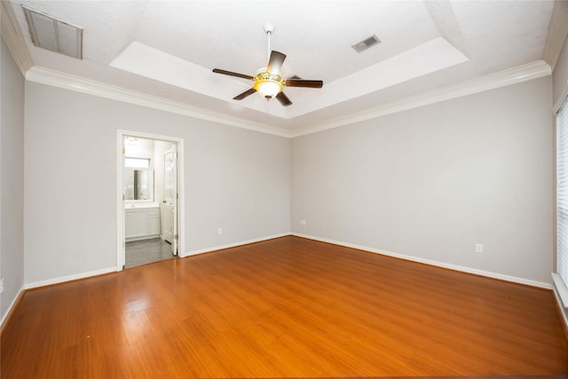 24526 Haigshire Dr, Tomball, TX 77375 - unfurnished room featuring a raised ceiling, wood finished floors, ceiling fan, ornamental molding, and healthy amount of natural light