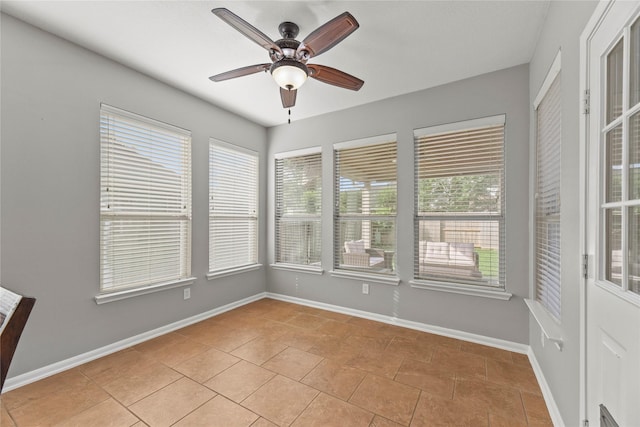 spare room with baseboards, a ceiling fan, and light tile patterned flooring