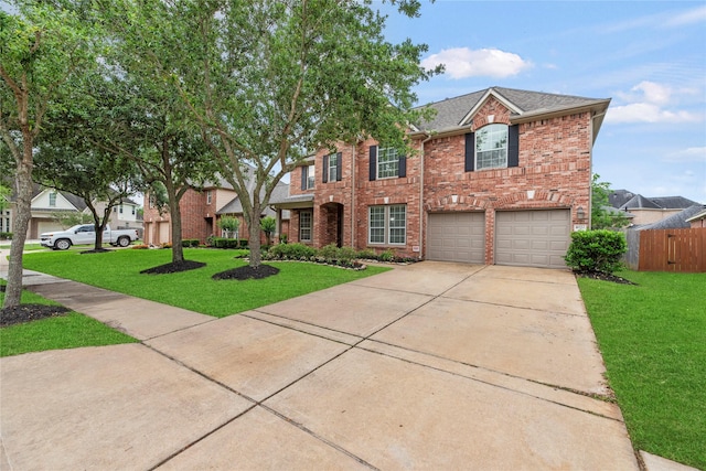 view of front of home with an attached garage, driveway, brick siding, and a front yard