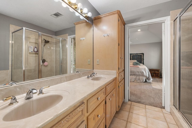 bathroom with a shower stall, tile patterned flooring, a sink, and visible vents