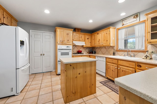 kitchen with a sink, tasteful backsplash, white appliances, light countertops, and under cabinet range hood