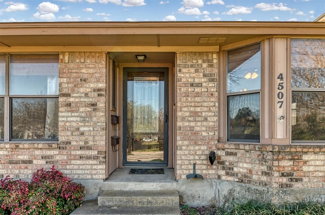 view of exterior entry featuring brick siding