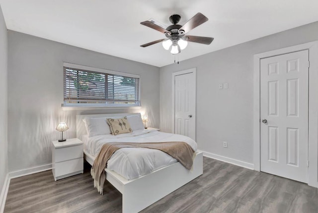 bedroom with baseboards, wood finished floors, and ceiling fan