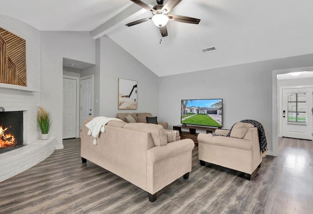 living area featuring visible vents, a ceiling fan, dark wood-type flooring, beam ceiling, and a brick fireplace