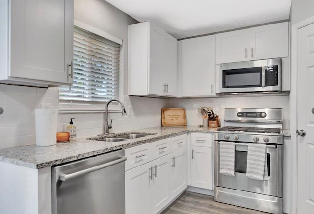 kitchen featuring white cabinets, appliances with stainless steel finishes, and a sink