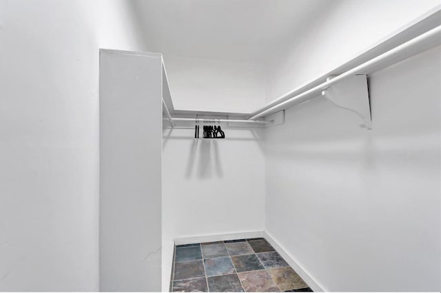 spacious closet featuring stone finish floor