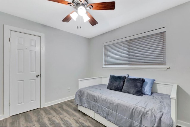 bedroom with ceiling fan, baseboards, and wood finished floors