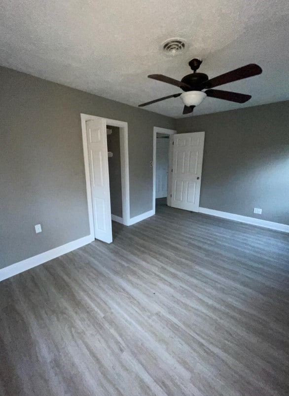 empty room featuring baseboards, a textured ceiling, and ceiling fan