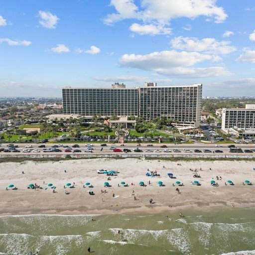 drone / aerial view with a beach view and a water view