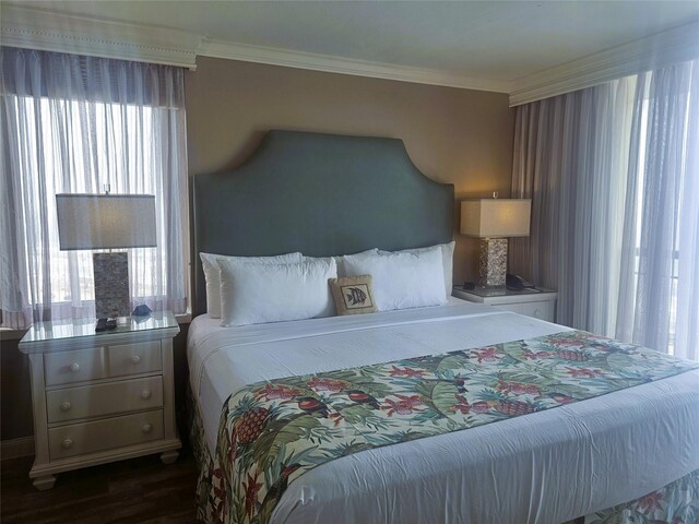 bedroom with ornamental molding and dark wood-type flooring