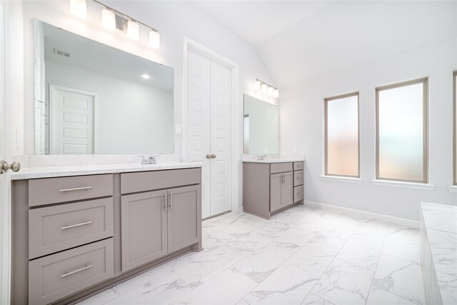 10419 Rigel Ridge Way, Richmond, TX 77406 - full bathroom featuring two vanities, marble finish floors, baseboards, and vaulted ceiling