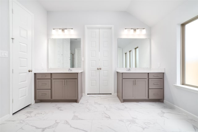 10419 Rigel Ridge Way, Richmond, TX 77406 - full bathroom featuring two vanities, plenty of natural light, marble look tile flooring, and vaulted ceiling