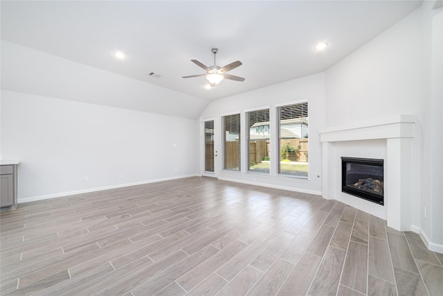 10419 Rigel Ridge Way, Richmond, TX 77406 - unfurnished living room with a ceiling fan, light wood-style floors, a glass covered fireplace, baseboards, and vaulted ceiling