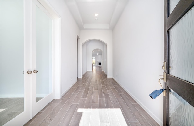 10419 Rigel Ridge Way, Richmond, TX 77406 - hallway featuring arched walkways, wood finished floors, baseboards, recessed lighting, and a tray ceiling