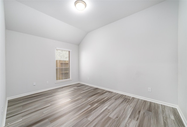 10419 Rigel Ridge Way, Richmond, TX 77406 - spare room with wood finished floors, baseboards, and vaulted ceiling