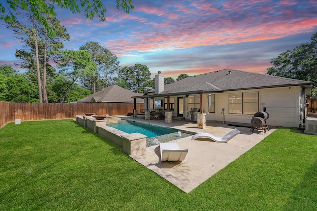 rear view of house featuring a patio, a fenced backyard, a chimney, a shingled roof, and a lawn