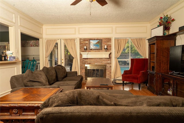 13710 Casaba Ct, Cypress, TX 77429 - living area with a textured ceiling, a ceiling fan, wood finished floors, a decorative wall, and a fireplace