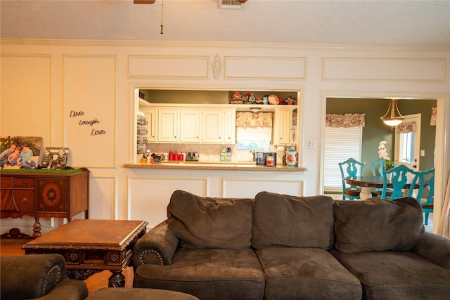 13710 Casaba Ct, Cypress, TX 77429 - living room featuring visible vents, a textured ceiling, and a decorative wall