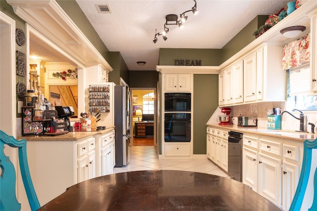 13710 Casaba Ct, Cypress, TX 77429 - kitchen with dobule oven black, freestanding refrigerator, visible vents, dishwashing machine, and light tile patterned floors