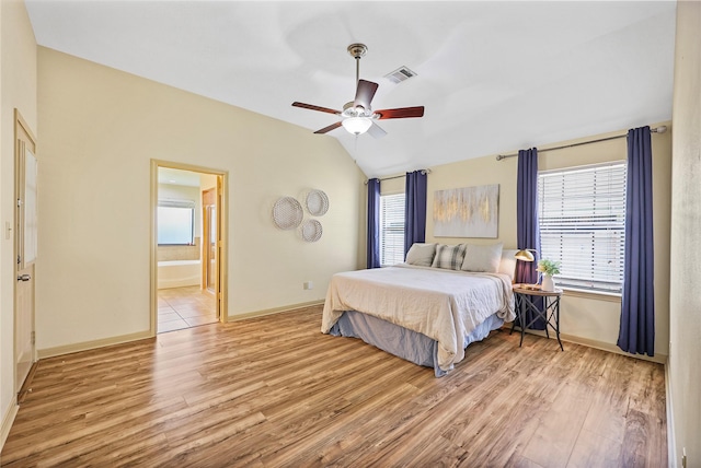 bedroom featuring visible vents, wood finished floors, vaulted ceiling, and multiple windows