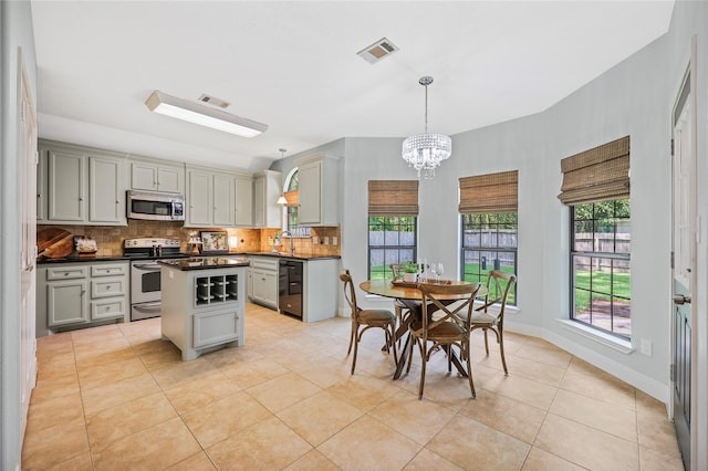 3226 Glen Forest Rd, Montgomery, TX 77356 - kitchen featuring appliances with stainless steel finishes, gray cabinetry, dark countertops, decorative backsplash, and light tile patterned floors