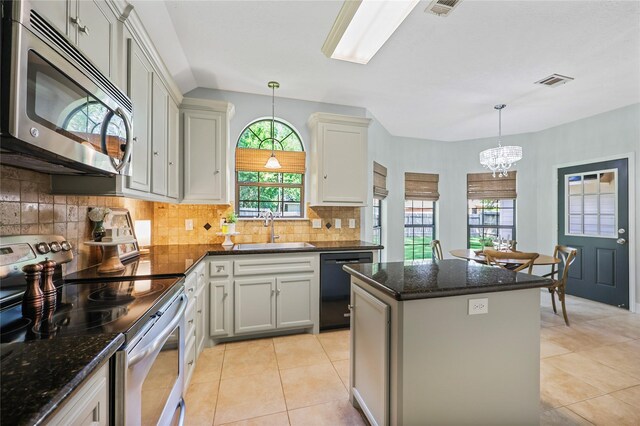 3226 Glen Forest Rd, Montgomery, TX 77356 - kitchen featuring stainless steel appliances, a sink, a kitchen island, light tile patterned floors, and decorative backsplash