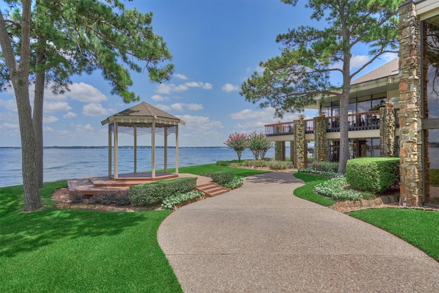 view of community with a yard, a water view, and a gazebo