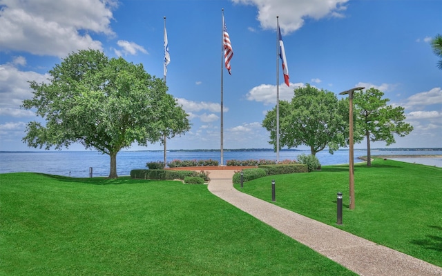 surrounding community with a lawn and a water view