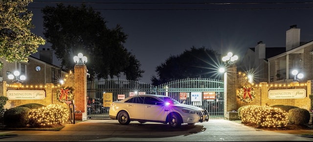 parking at twilight featuring a gate and driveway