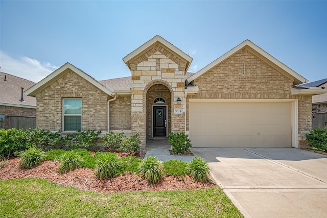 view of front of house with brick siding, driveway, and a garage