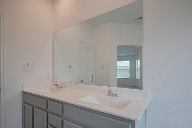 full bathroom with visible vents, a sink, and double vanity