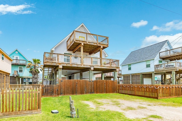 rear view of house featuring fence, a yard, and a deck