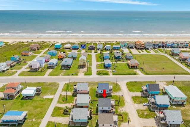 drone / aerial view featuring a beach view and a water view