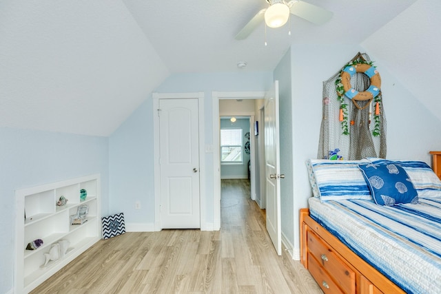 bedroom featuring a ceiling fan, baseboards, lofted ceiling, and light wood-type flooring