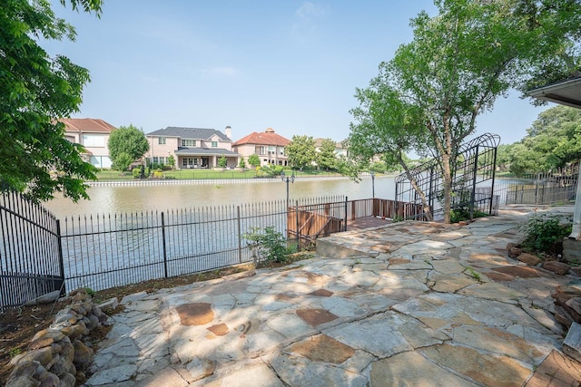 view of patio with fence private yard, a residential view, and a water view