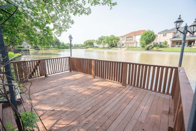 wooden deck with a residential view and a water view