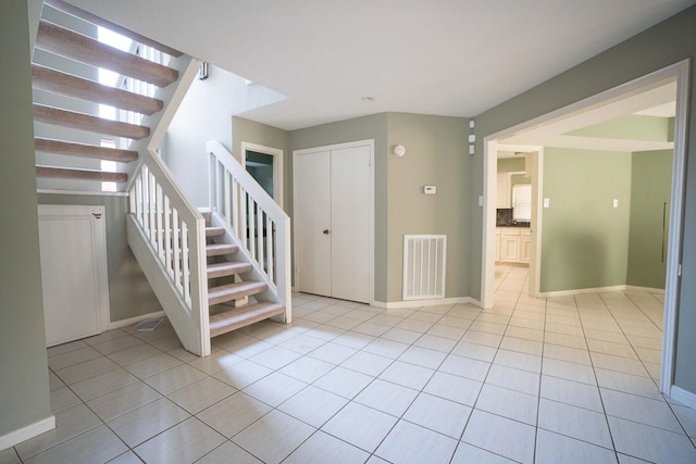 stairs with baseboards, visible vents, tile patterned flooring, and a wealth of natural light