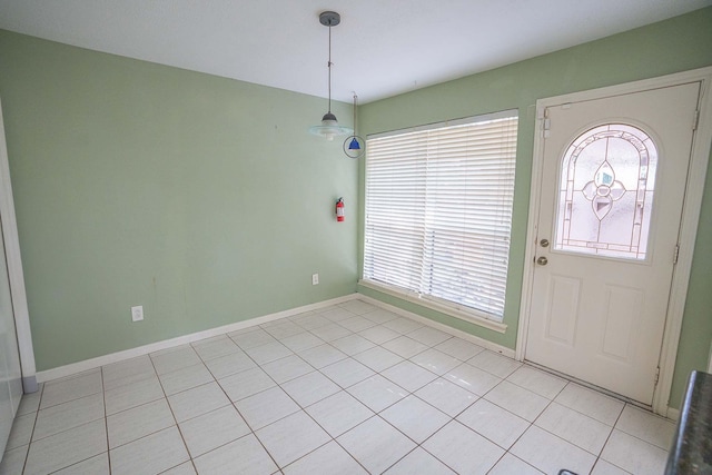foyer featuring baseboards, a healthy amount of sunlight, and light tile patterned flooring