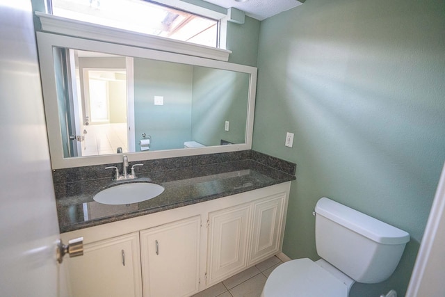 bathroom featuring vanity, tile patterned flooring, and toilet