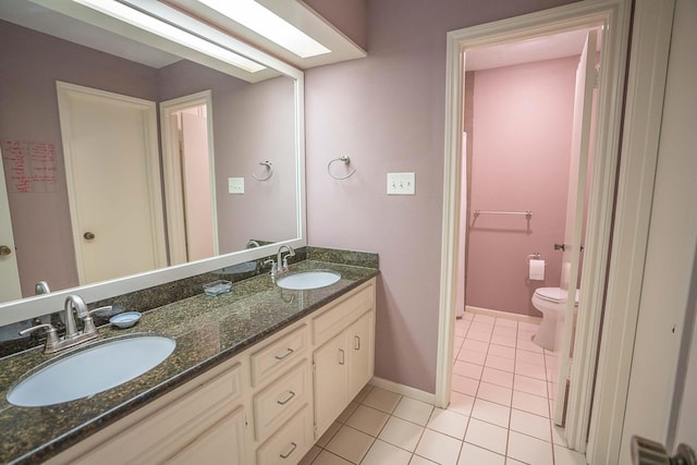 full bathroom featuring tile patterned flooring, a sink, double vanity, and toilet