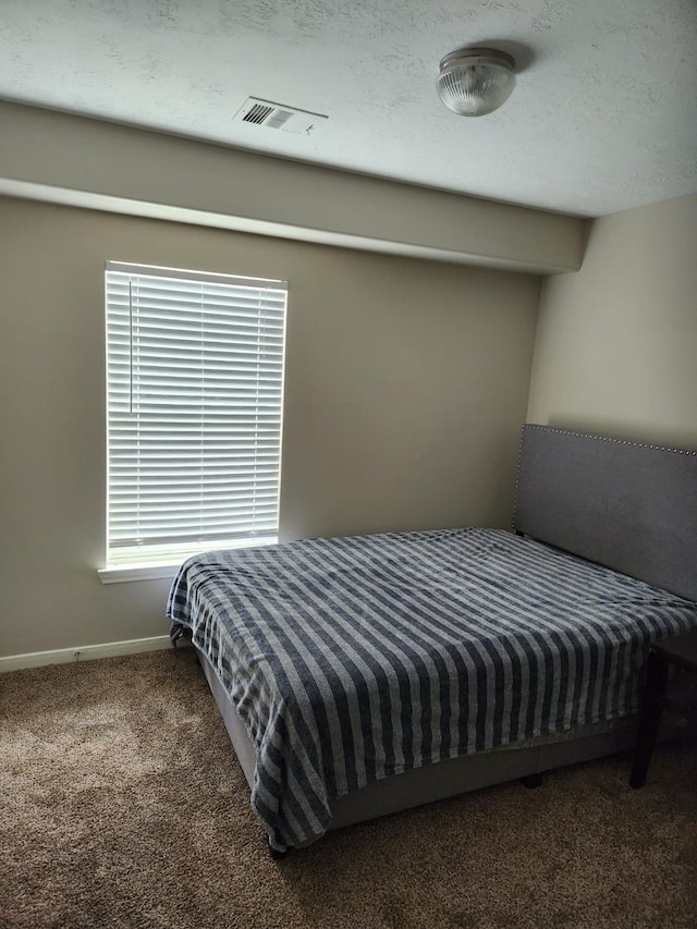 carpeted bedroom featuring visible vents and baseboards