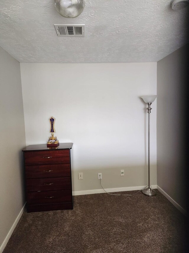 15903 Winston Point Ln, Houston, TX 77084 - unfurnished bedroom with a textured ceiling, dark colored carpet, and baseboards