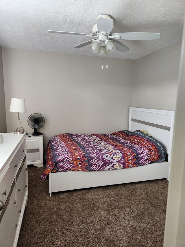 15903 Winston Point Ln, Houston, TX 77084 - bedroom with dark carpet, a textured ceiling, and a ceiling fan