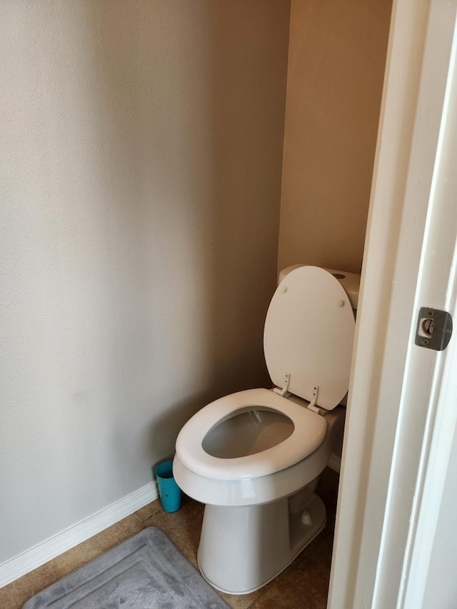 bathroom with baseboards, toilet, and tile patterned floors