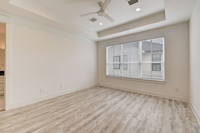 2718 Oakwood Crest Ln, Houston, TX 77018 - empty room with light wood-type flooring, ceiling fan, visible vents, and a raised ceiling